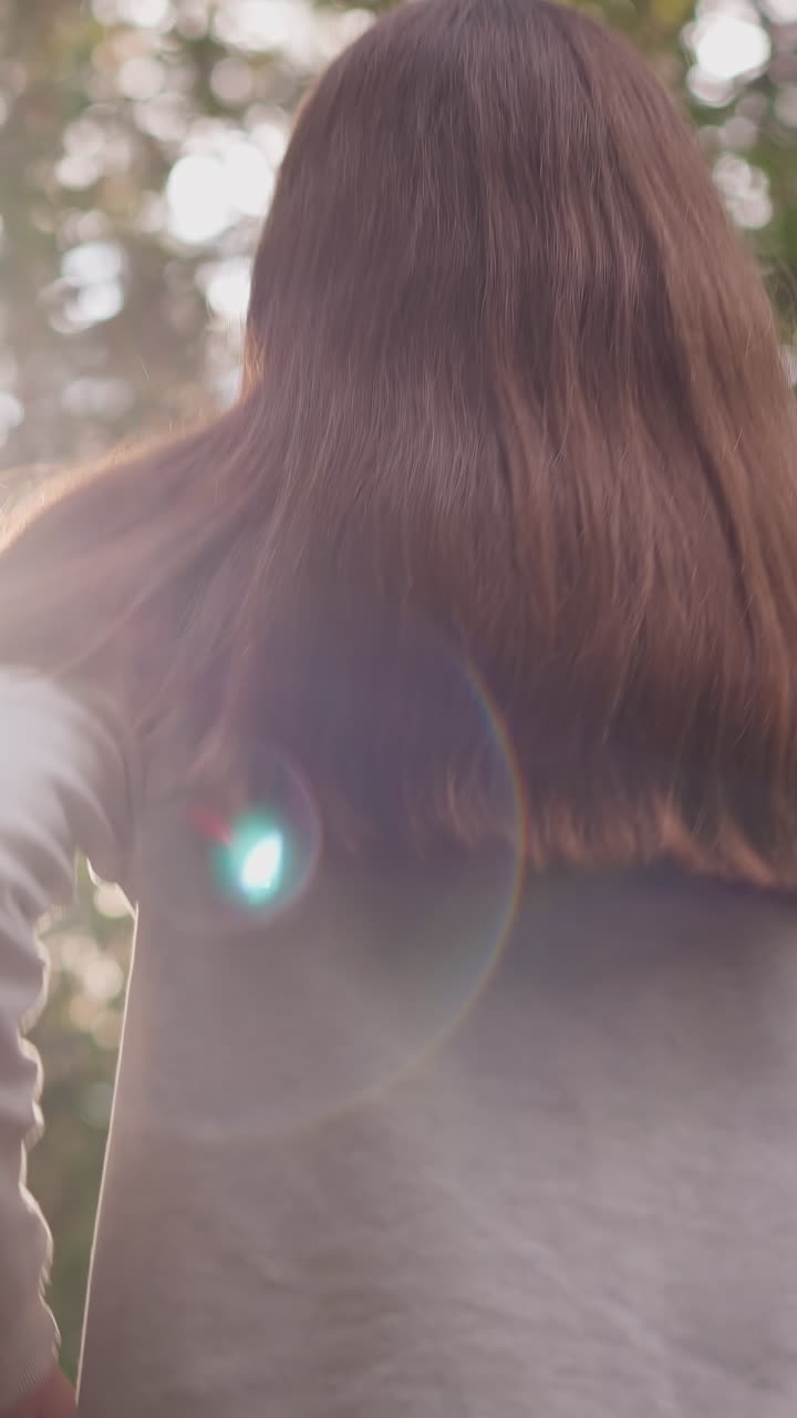 긴 느슨한 머리카락을 가진 여자는 아침에 조합니다. 젊은 여자는 숲에서 따뜻한 여름날에 스트레스를 해소하는 복지를 향상시키기 위해 신체 운동을 수행합니다.