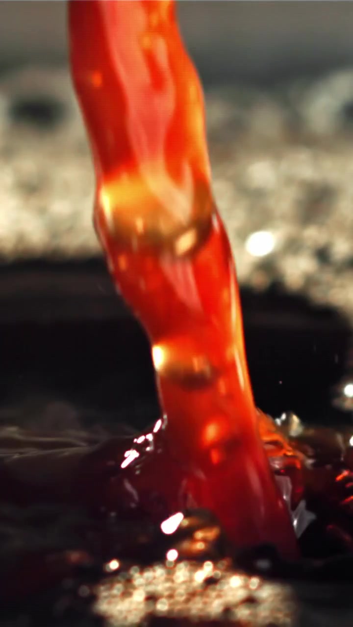 Primo piano al rallentatore di liquido marrone intenso che si versa