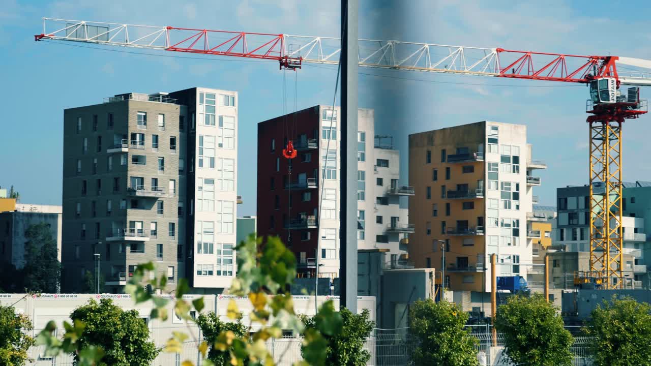 Scena di costruzione urbana con moderni condomini e un'imponente gru sullo sfondo di un cielo blu a Nantes, in Francia. Concept di sviluppo ed espansione edilizia