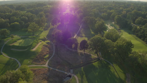 Distancia-Aérea-Sobre-Un-Hermoso-Campo-De-Golf-Al-Atardecer