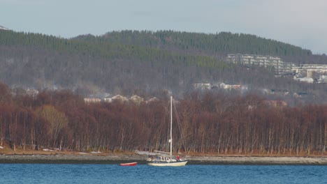 Pequeño-Bote-Navegando-A-Lo-Largo-Del-Fiordo-En-El-Norte-De-Noruega,-Teleobjetivo-Disparado-En-Cámara-Lenta-De-60-Fps