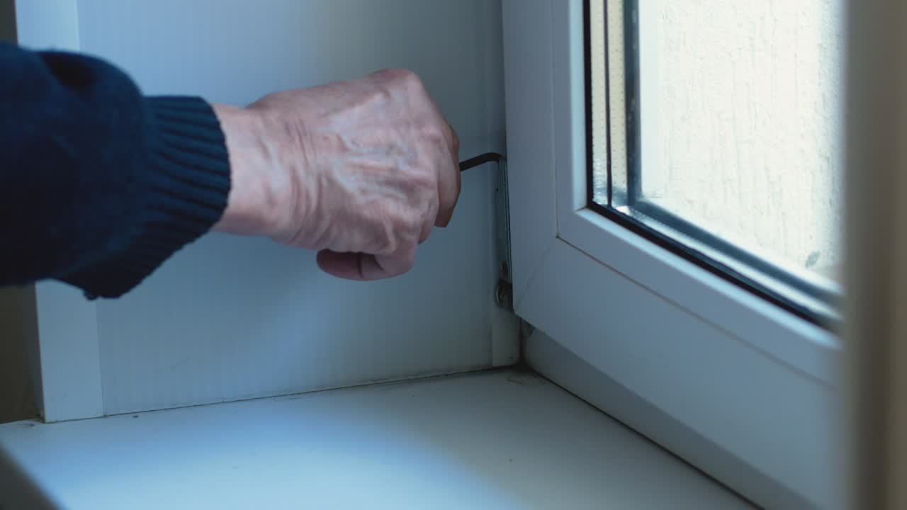 The master adjusts the sashes of plastic doors during repair and construction inside the house. Installation of plastic windows and doors, adjustment of fittings with a key