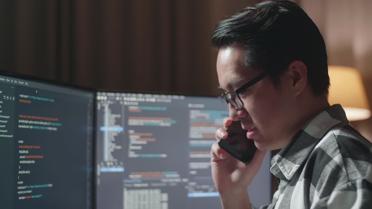 Programmer on phone call while coding late at night