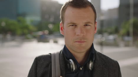 close up portrait of successful caucasian businessman looking serious at camera confident in urban city background