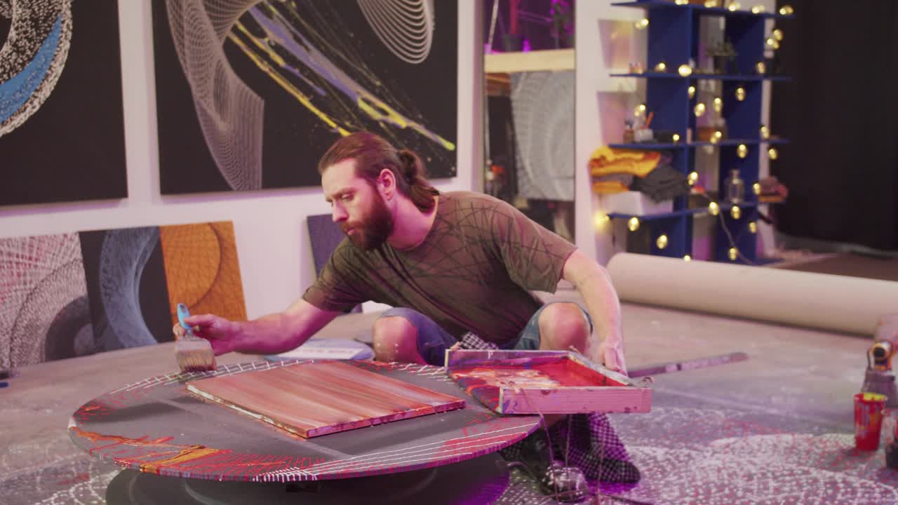 un hombre está sentado y pintando un cuadro