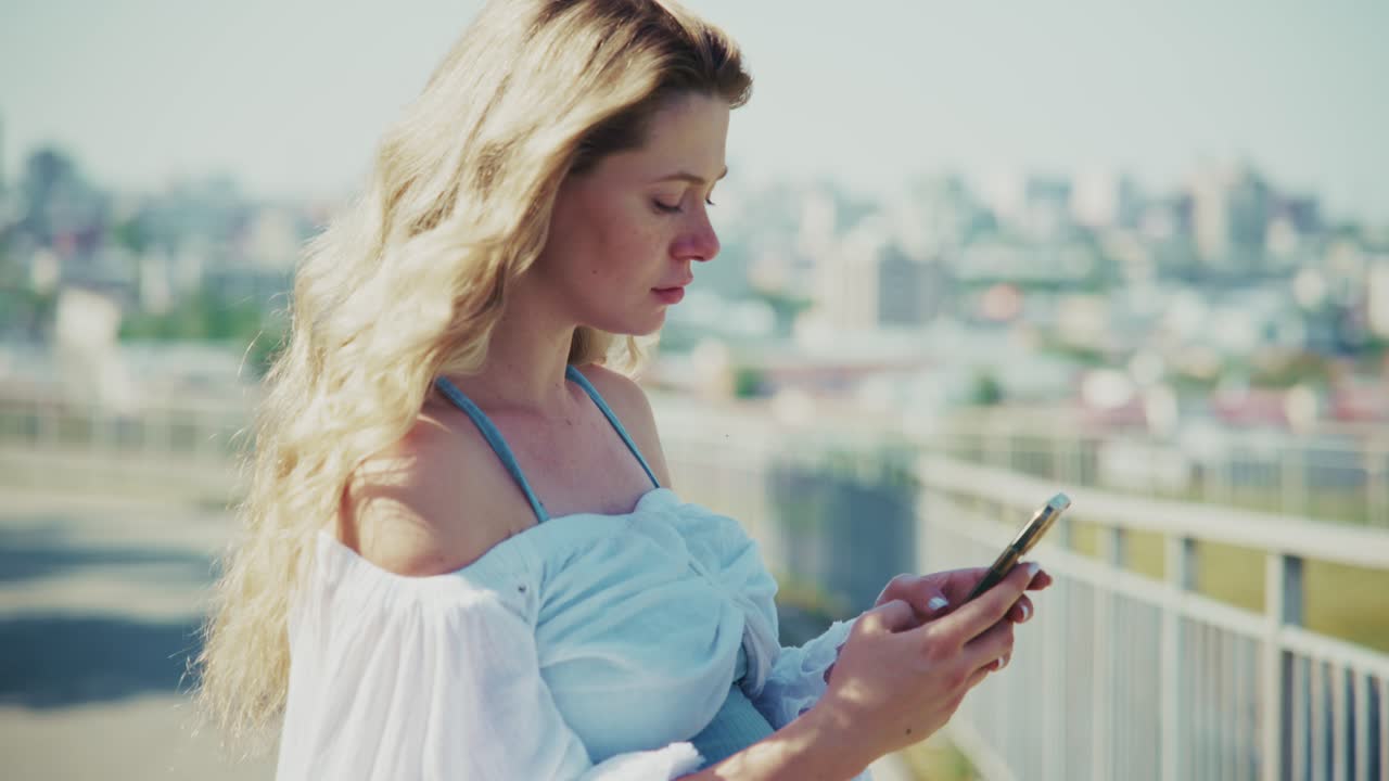 Giovane donna che usa lo smartphone all'aperto con lo sfondo della città