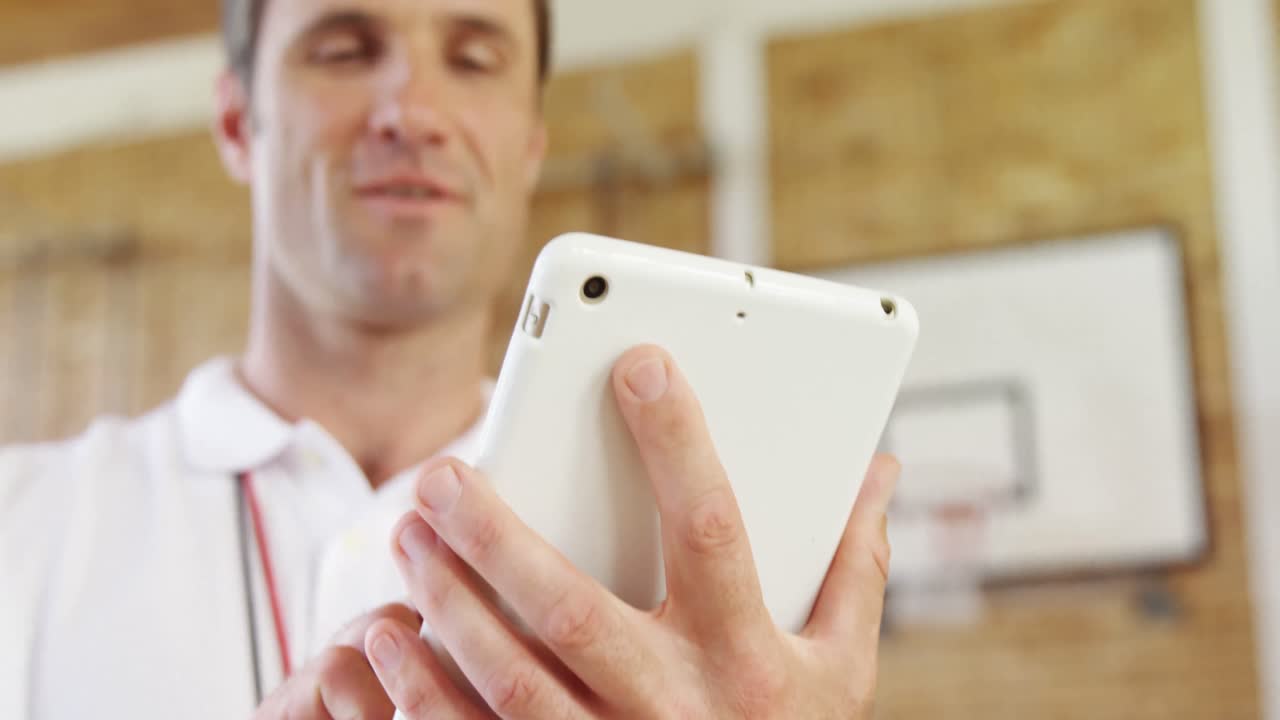 entrenador de baloncesto usando una tableta digital