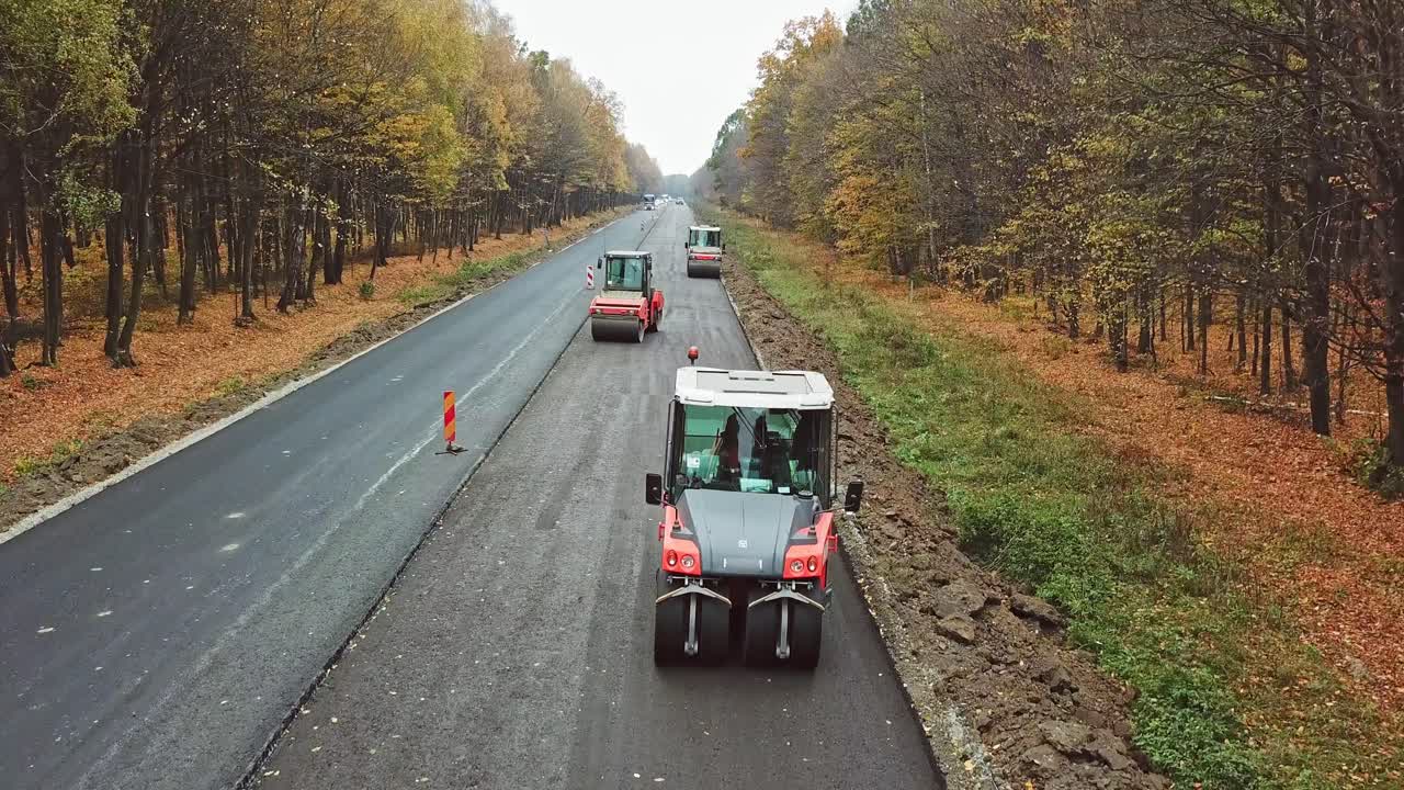 Asphalt road construction. Aerial view on the road rollers working on the new road construction site