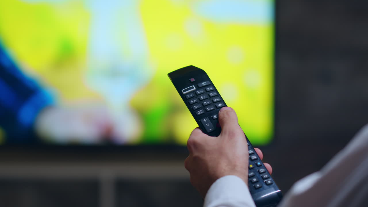 Back view of businessman using tv remote control