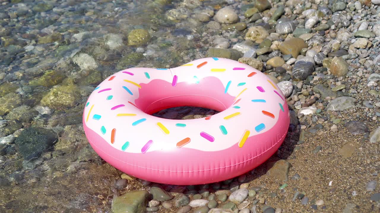 Inflatable colorful Rubber Ring floating on the seashore