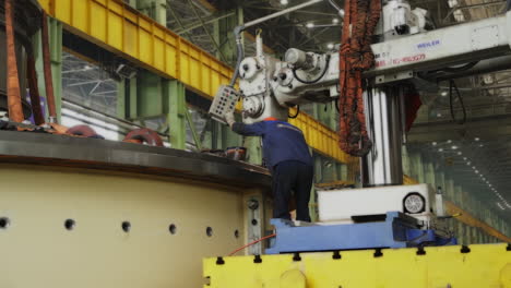 industrial worker operating large machine in factory