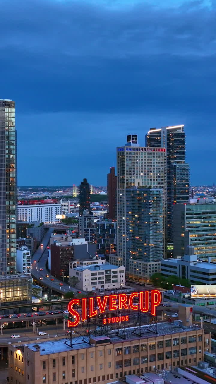 Well-known film Silvercup Studios in New York. Fantastic city architecture with evening lights. Blue sky background. Vertical video
