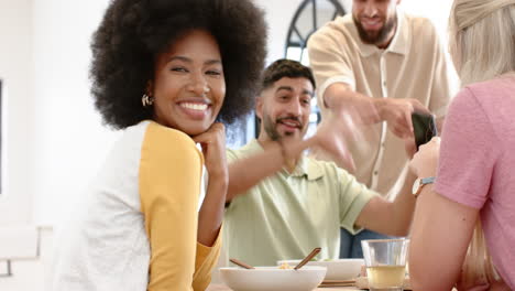 smiling friends enjoying meal together, laughing and having fun indoors