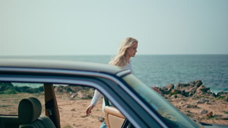 woman near a vintage car on a beach