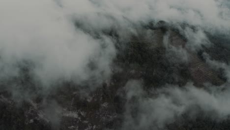 drone aerial flying over the clouds towards a mountian and rainforest in guatemala