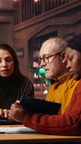 vertical video mature team of people reviewing materials and class work for university degree