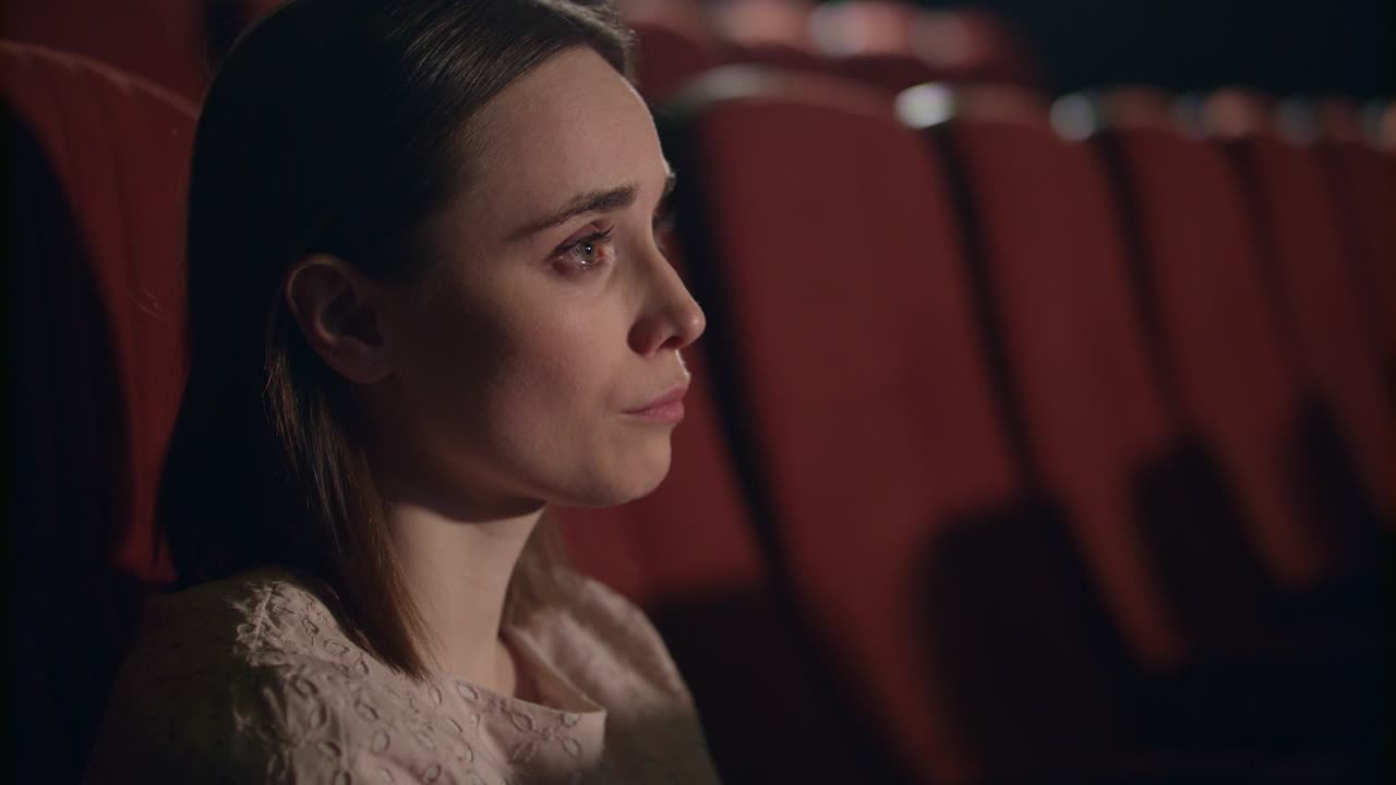chica viendo una película triste en el cine. mujer llorando en el melodrama