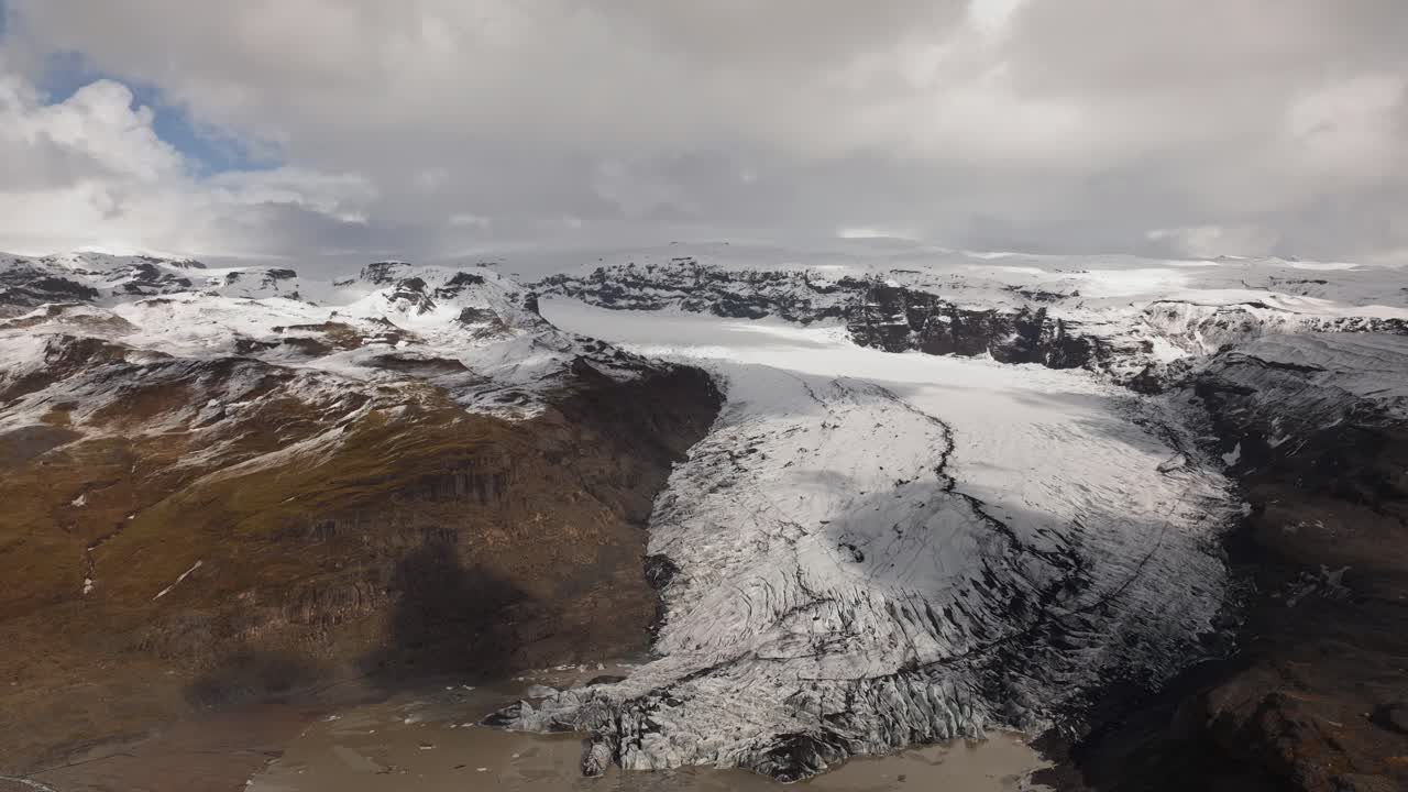 아이슬란드의 솔헤이마요쿨 빙하의 공중 하이퍼 스 (aerial hyperlapse of solheimajökull glacier in iceland) 는 창하는 얼음 형성과 주변 산악 풍경과 빠르게 움직이는 구름을 보여줍니다.