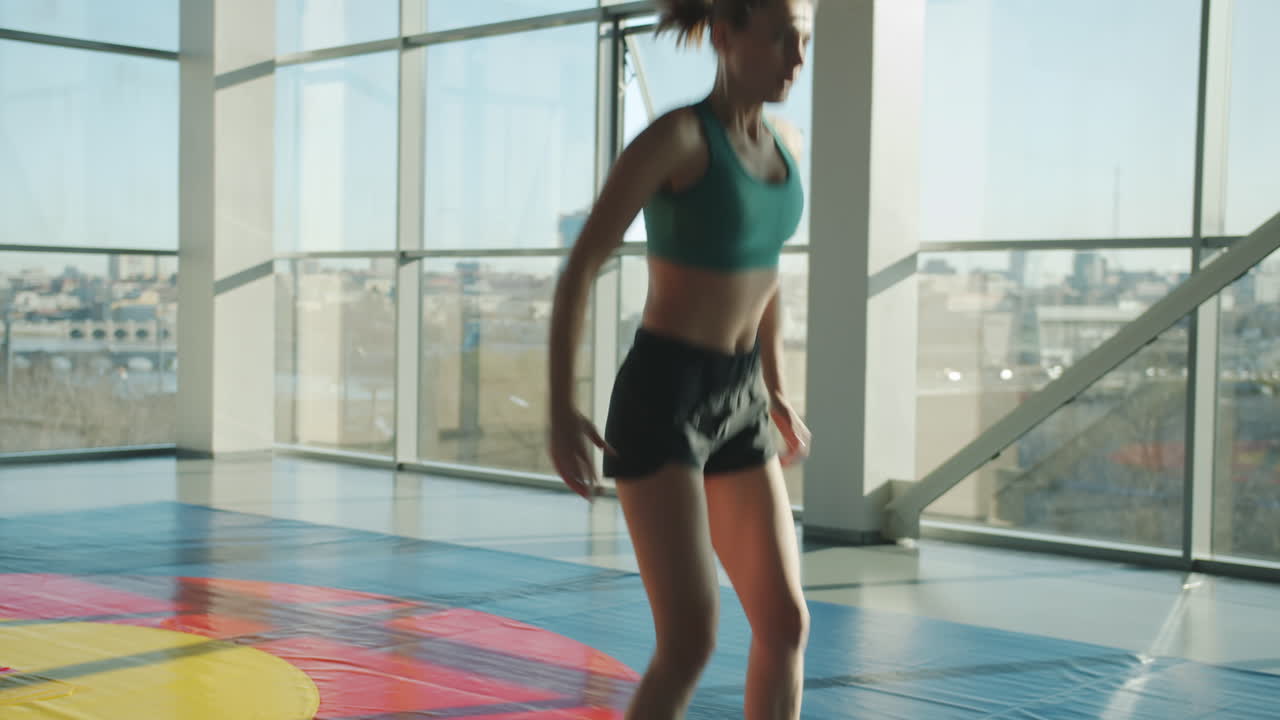Woman performing a jump exercise in a modern gym