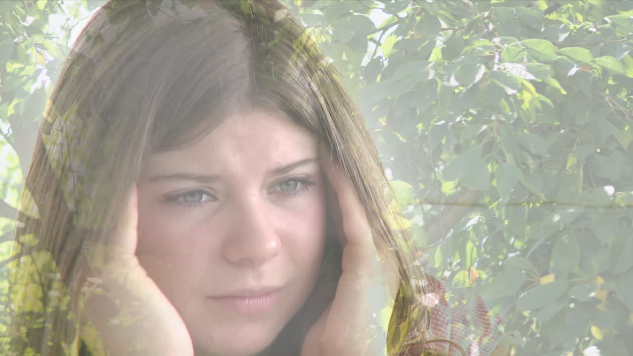 높은 나무의 잎에 대항하여 스트레스를 받은 백인 여성의 복합 비디오