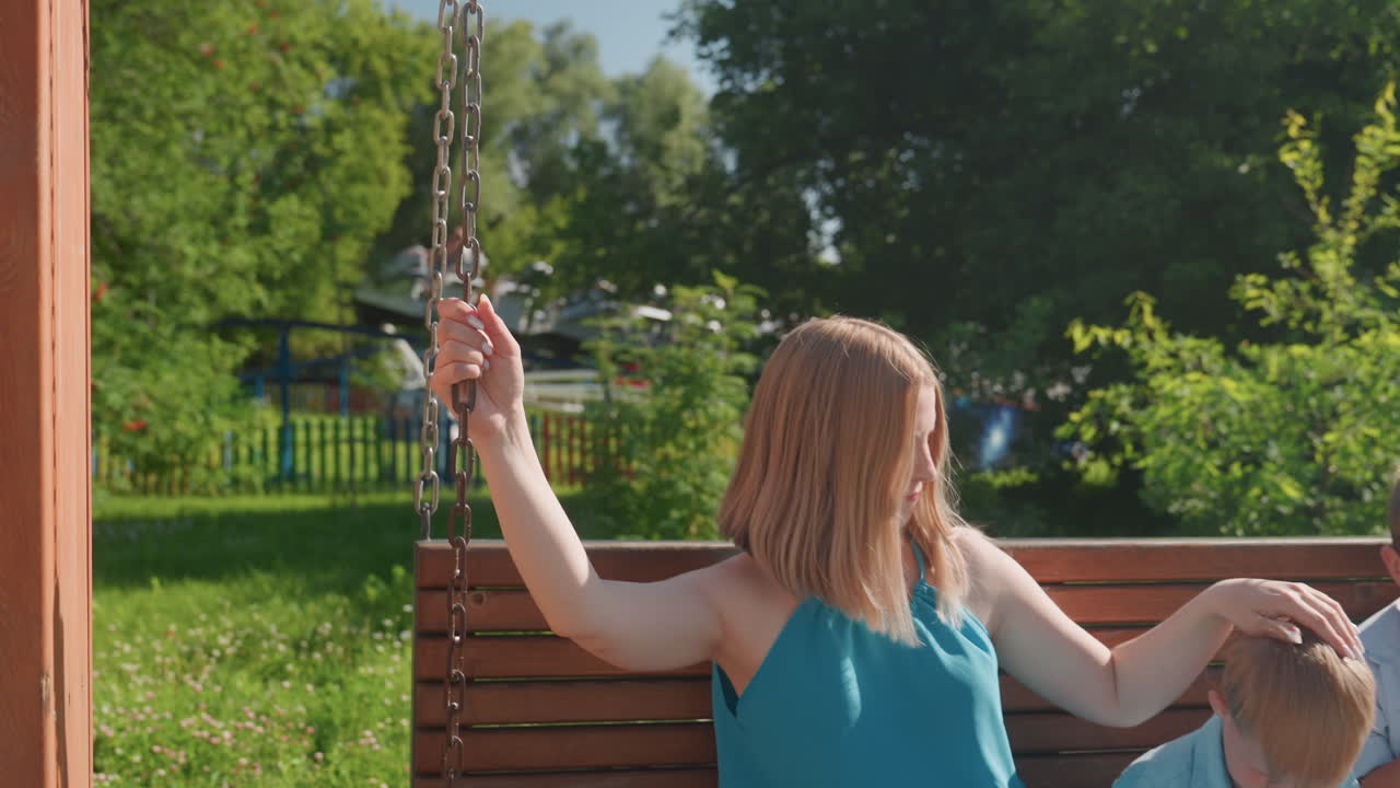 Mère observe ses enfants s'amusant en plein air. Femme en tenue décontractée regardant des enfants jouer dehors. Femme observant tranquillement des enfants engagés dans des activités joyeuses dans un parc serein.