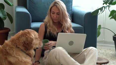 woman drinking coffee and working with beautiful labrador dog