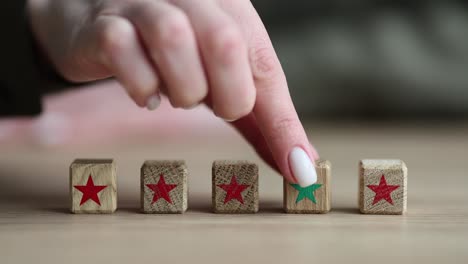 hand selecting a green star block among red star blocks, symbolizing a positive rating or choice