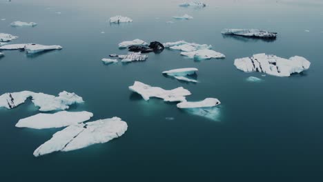 a drone takes flight over a glacier lagoon, its surface a canvas for icebergs to create their own masterpieces