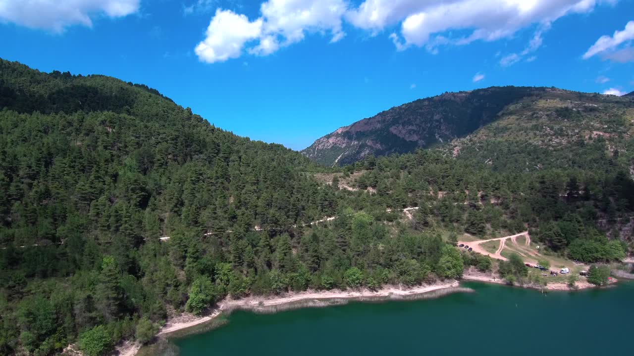 Aerial crane shot of Lake Tsivlou with mountains surrounding peacefully the natural waters on an overcast cloudy day