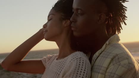 Man-embracing-woman-at-beach-during-sunset-4k