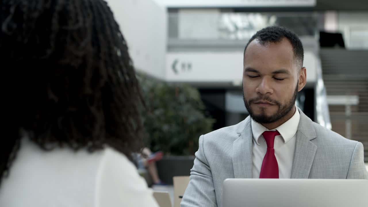 Dois trabalhadores alegres sentados em um café e conversando