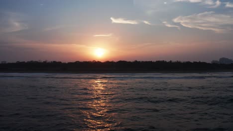 Colorful-Drone-Aerial-Footage-of-a-beach-ocean-water-during-sunset