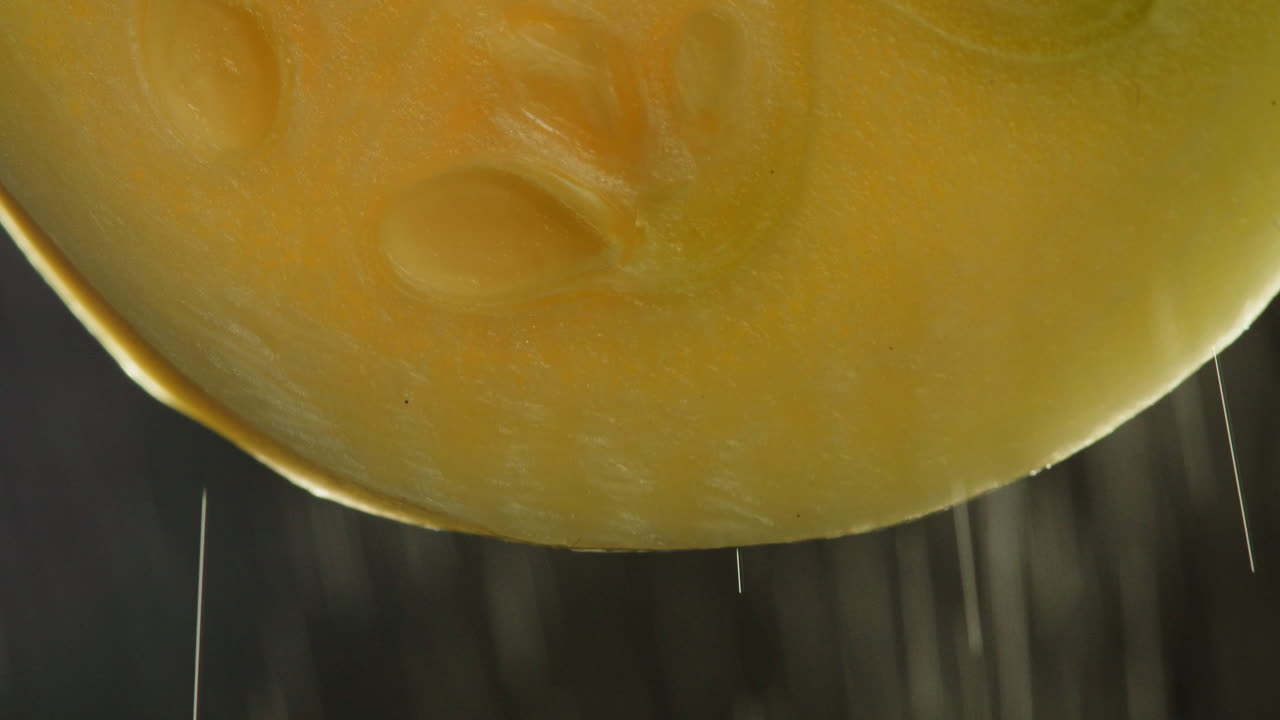 Close-up of Fruit Slice with Water Dripping and Spraying
