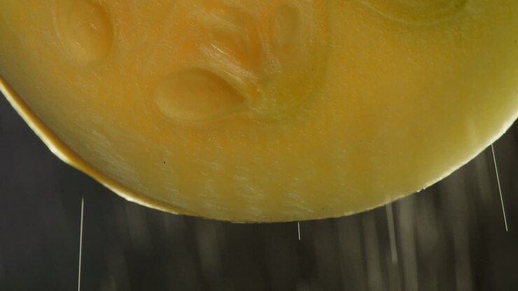 Close-up of Fruit Slice with Water Dripping and Spraying