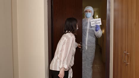 doctor with inscription text visiting woman patient at home offering vaccination against coronavirus