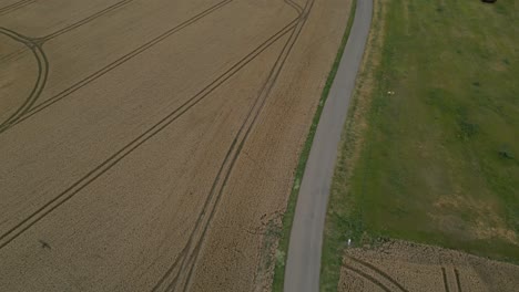 Aerial-View-Over-Road-Between-Agricultural-Fields-In-Poland---Drone-Shot