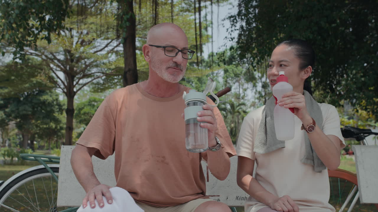 Active Mature Spouses Drinking Water after Exercising in Park