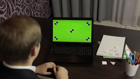 hombre haciendo una llamada de video en línea en una computadora portátil. pantalla verde. educación a distancia
