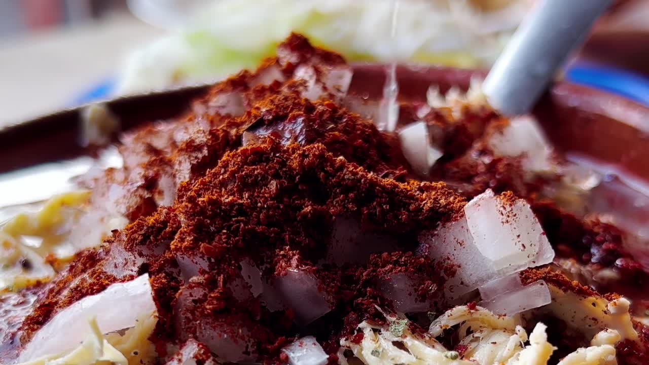 Vista dettagliata di un lime spremuto su una gustosa ciotola di pozole.
