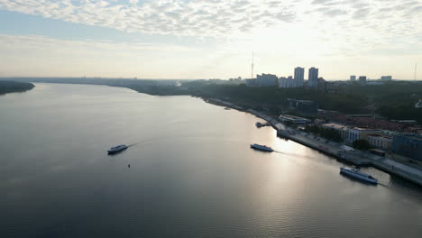 aerial view of a city river with boats and embankment