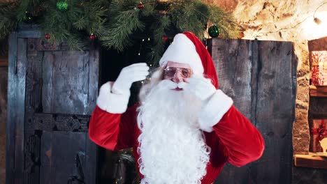 cheerful santa claus dances, sings and waves his hands in his residence