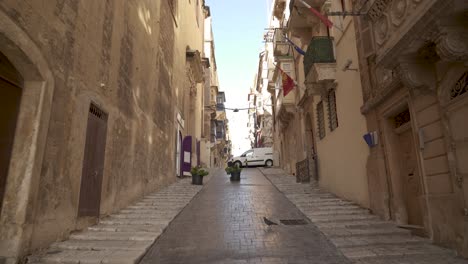 walking on a steep cobblestone path in valletta city on a sunny day in malta