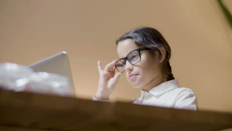 bottom shot of smart schoolgirl doing homework