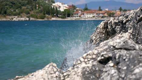 close-up on foamy waves of the ionian sea crashing against a rocky cliff on corfu island