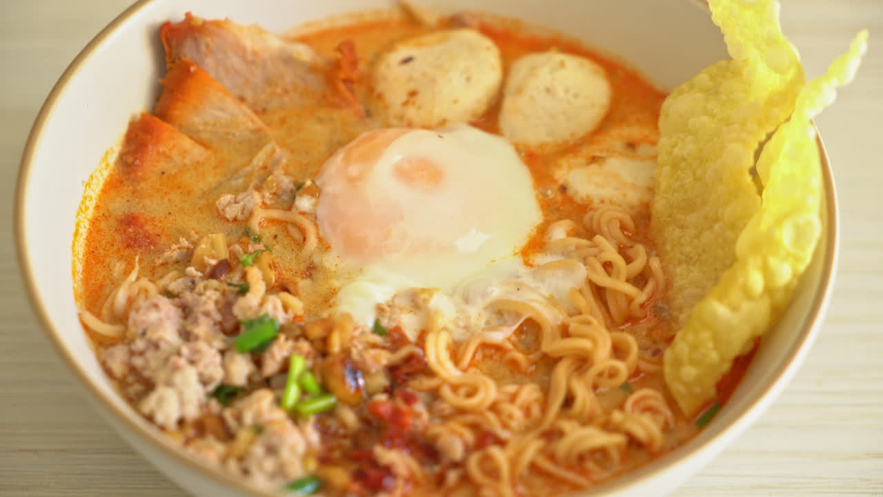 fideos instantáneos con carne de cerdo y albóndigas en sopa picante o fideos tom yum al estilo asiático