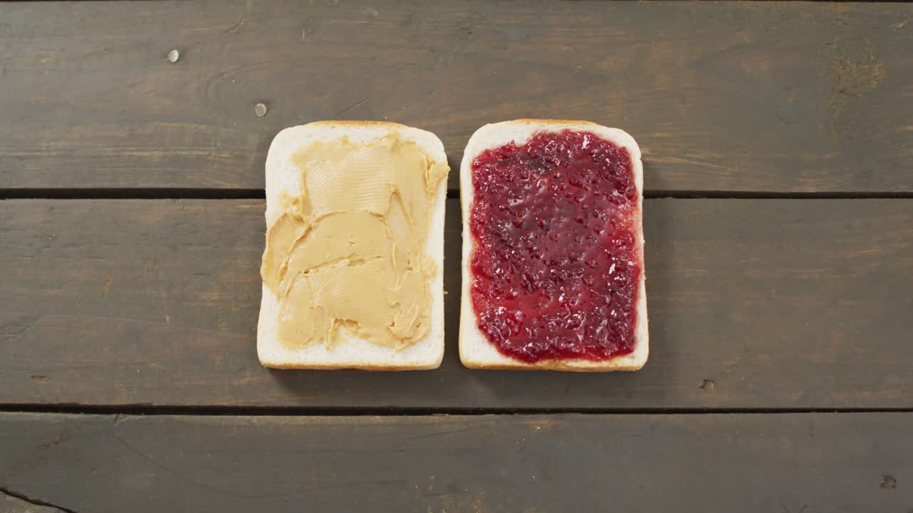 Primo piano di un sandwich con burro d'arachidi e marmellata con spazio per il testo su superficie in legno.