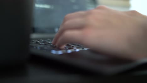 caucasian guy typing on laptop computer, shallow focus low side angle