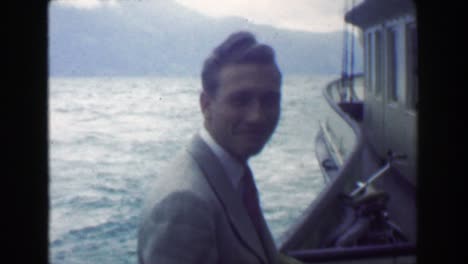 1949: formally dressed happy man cruise ship transport on big river.