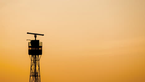 Zeitraffer-Der-Silhouette-Des-Meeresradarturms-Mit-Rotierender-Antenne-Bei-Sonnenuntergang