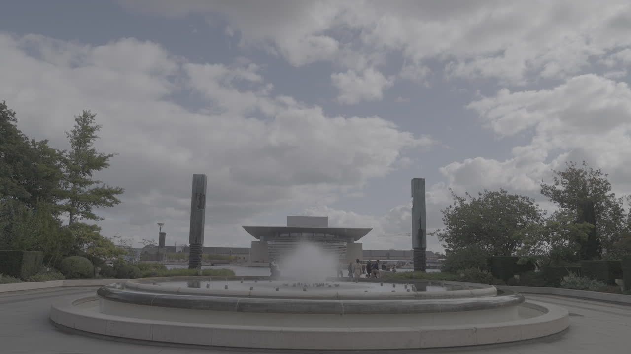 Fountain across the Copenhagen Opera in Denmark in slow motion on a cloudy day LOG